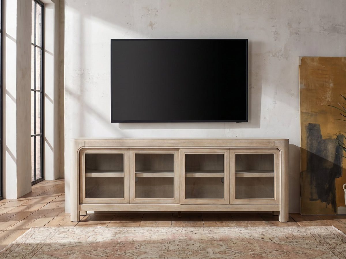 Albenga 71-Inch Weathered Mango Veneer Sliding Glass Door Media Console under a wall-mounted screen in an industrial loft