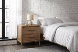 Alghero brown oak nightstand with a ceramic lamp beside a bed in a Chicago loft bedroom with a whitewashed brick wall and a black steel window