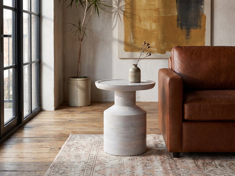 Aliano Whitewashed Mango Tray-Top Side Table beside a leather sofa in an industrial loft