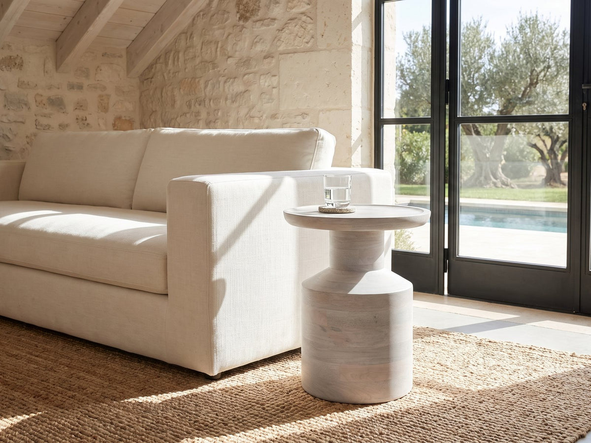 Aliano Whitewashed Mango Tray-Top Side Table beside a linen sofa in a poolside villa