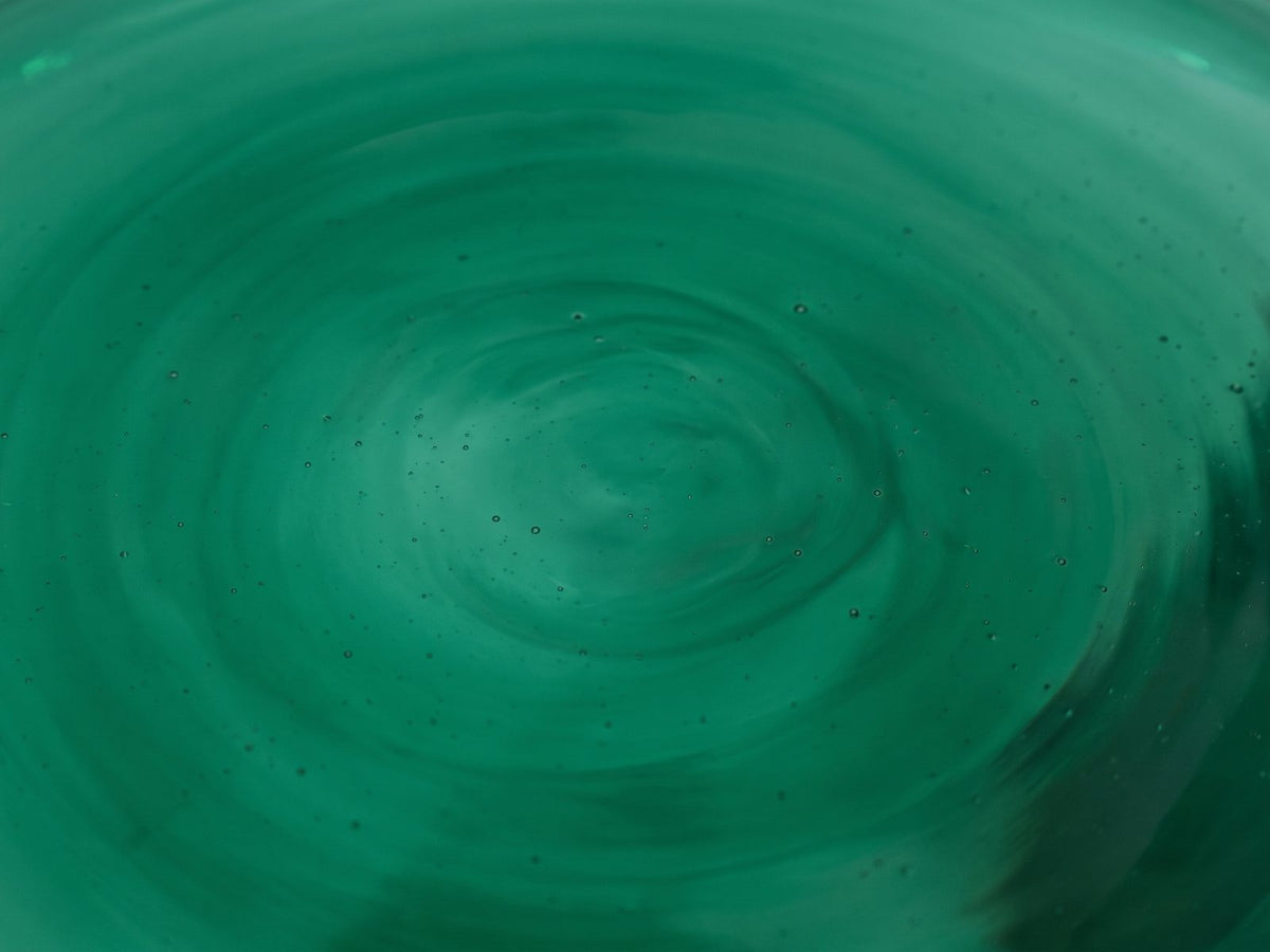 Close-up of the Alliste Blown Glass Hourglass Side Table: the emerald blown glass of the top