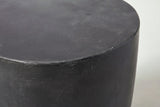 Close-up of the matte black lightweight concrete on the Altavilla side table, with light brushed marks along the top edge