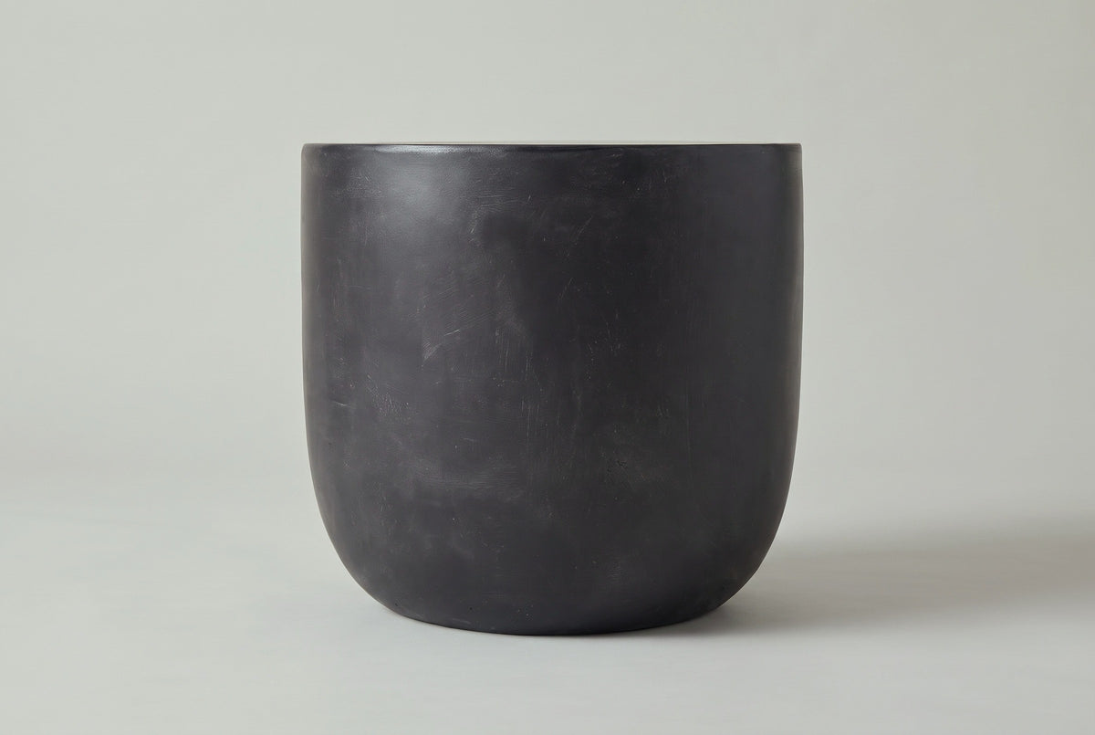 The Altavilla side table seen straight from the side: straight upper sides curving in to a smaller flat base