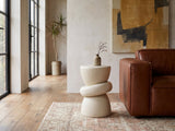 Altomonte Cream Fiberglass Stacked Side Table beside the arm of a cognac leather seat in an industrial loft