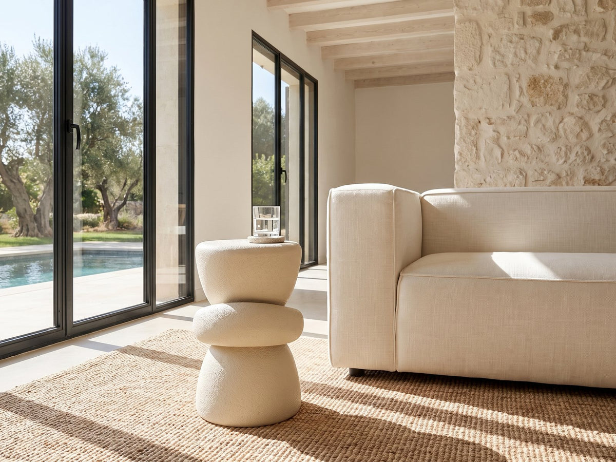 Altomonte Cream Fiberglass Stacked Side Table beside a linen sofa in a poolside villa