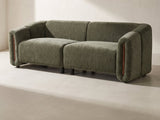 Amalfi Curved Sofa in olive green against a plaster wall in morning light