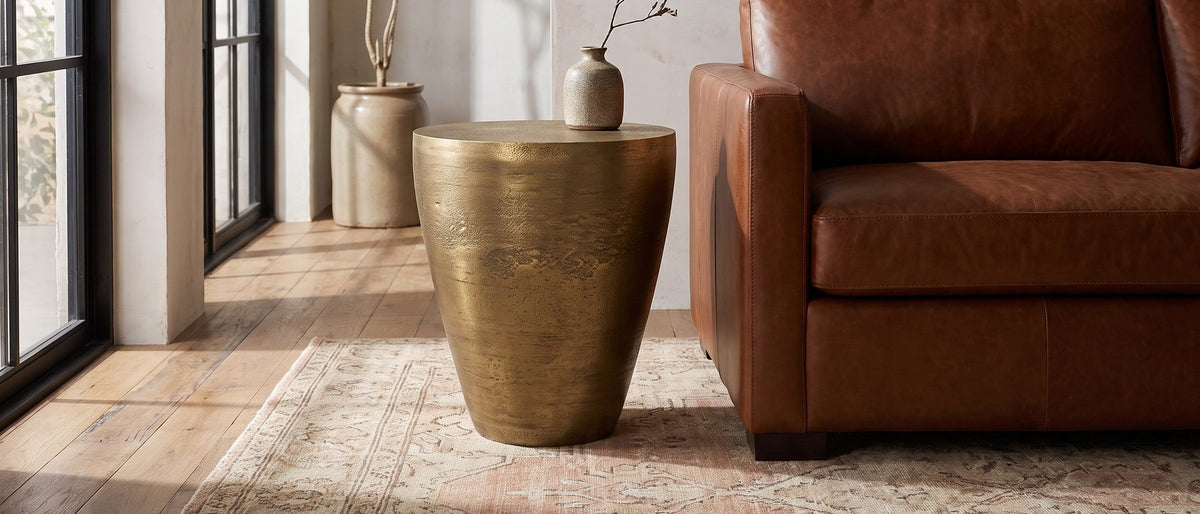 Capestrano Antique Brass Cast Aluminum Drum Side Table in the room