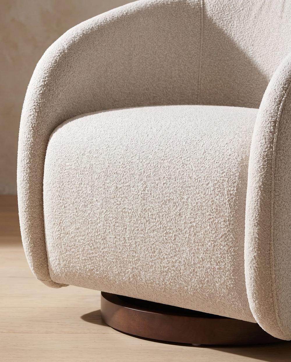 The walnut-finished round base set back under the boucle body