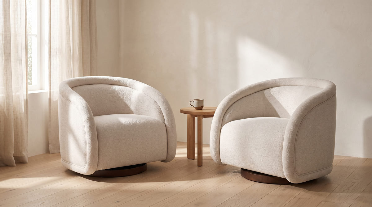 Two Carina swivel chairs angled toward each other with a small oak table between them