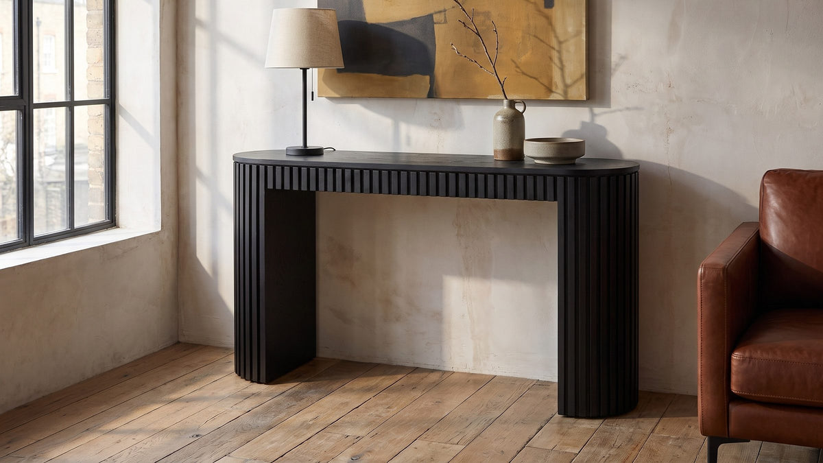 A long black line on the wall. - Monterosso Black Wood Veneer Fluted Oval Console Table