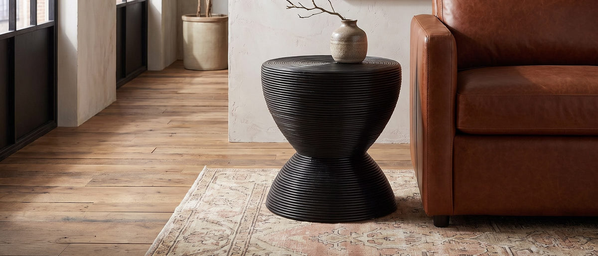 Tricase Black Rattan Hourglass Side Table in the room