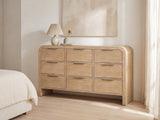 Aquileia 63-Inch Natural Mango 9-Drawer Dresser against a plaster wall under an abstract canvas in a bright bedroom