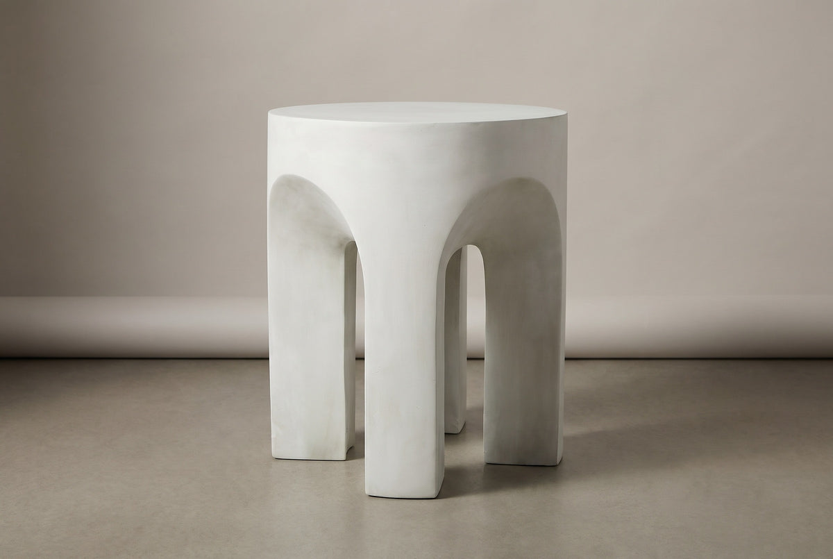The Aragona antique white arched side table, three-quarter view on a light studio backdrop