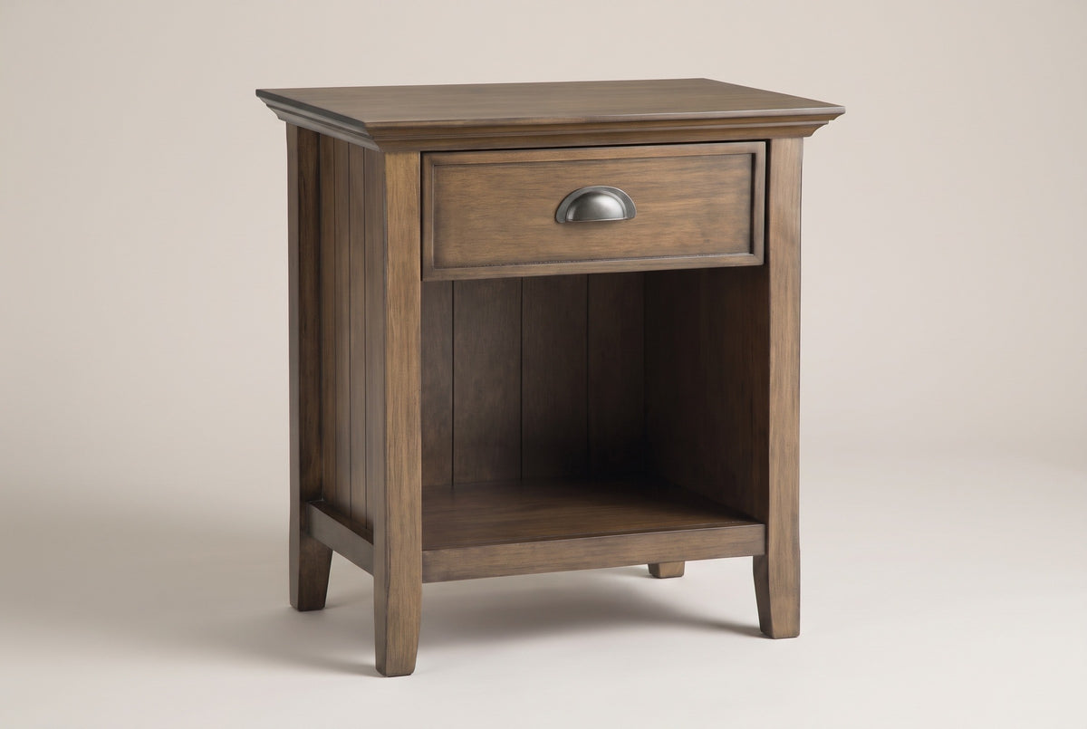 The Arbus one-drawer nightstand in rustic aged brown with a metal cup pull and an open beadboard cubby, three-quarter view on a light studio backdrop