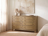 Arqua 61-Inch Natural Pine 8-Drawer Dresser against a plaster wall under an abstract canvas in a bright bedroom
