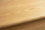 Close-up of the wire-brushed white oak veneer on the Arzachena nightstand: open pores and soft arches running to a rounded edge