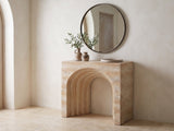 Asiago Faux Travertine Arched Console Table under a round mirror in a travertine entryway