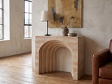 Asiago Faux Travertine Arched Console Table against a plaster wall in an industrial loft