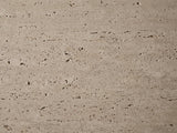 Close-up of the Asiago Faux Travertine Oval Mushroom Coffee Table: the pitted, matte travertine-look texture of the top