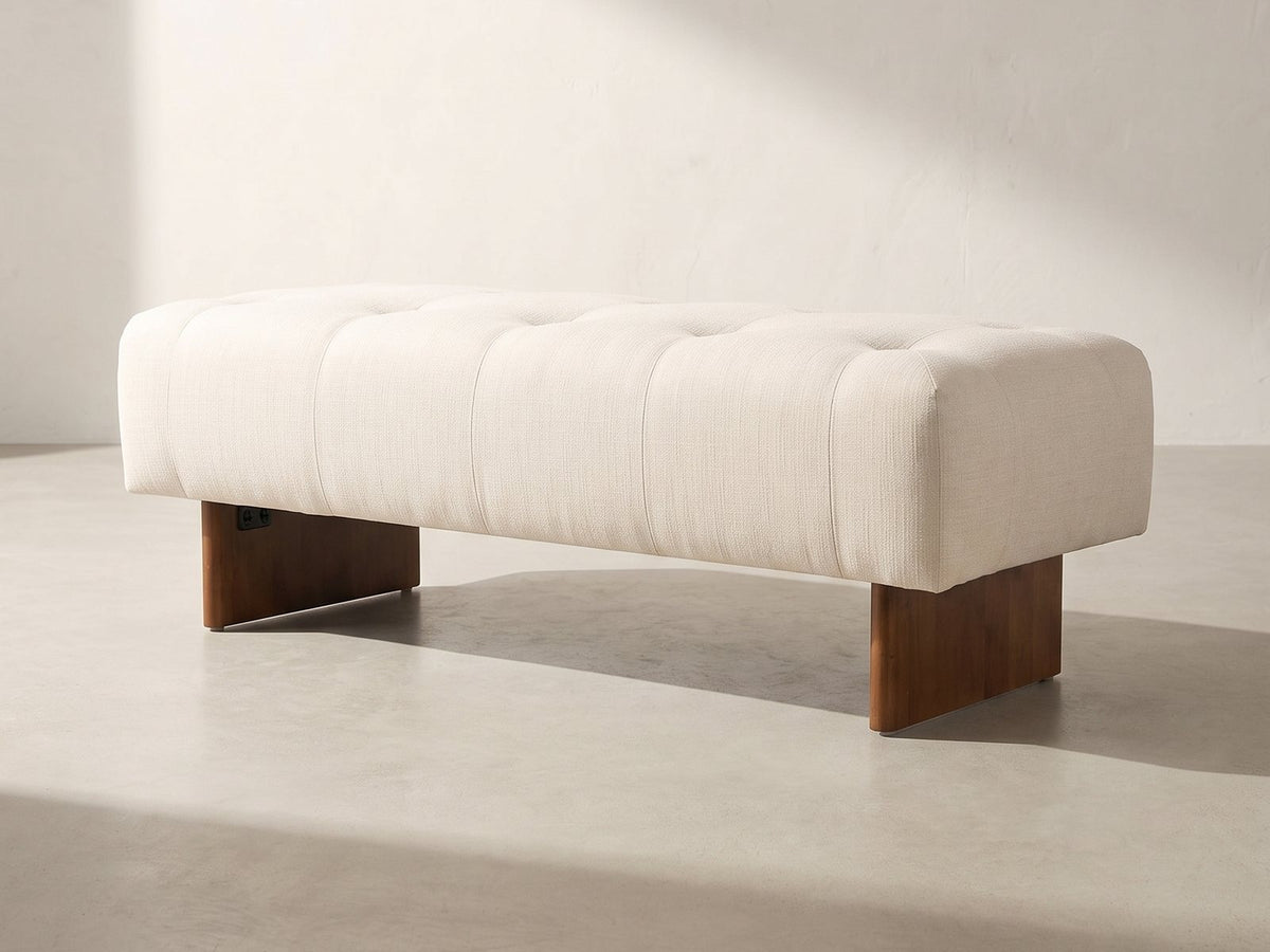 Assisi Tufted Bench in ivory against a plaster wall in morning light