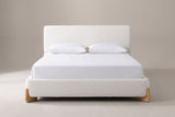 Atessa bed in white boucle with a white mattress and pillows (not included), front view