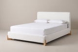 The Atessa bed in white boucle with a white mattress and pillows (not included), three-quarter view on a light studio backdrop
