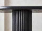 Close-up of the Atina Black Ash Oval Console Table: a reeded black ash leg meeting the rounded edge of the top