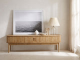 Atrani Reeded Curved Media Console styled with a leaning print, a lamp and ceramics in a bright plaster room