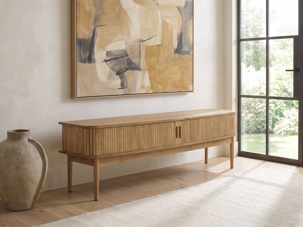 Atrani Reeded Curved Media Console seen from the side, under a large abstract painting in a bright living room