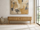 Atrani Reeded Curved Media Console under a large abstract painting in a bright living room