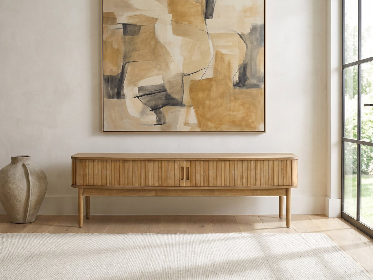 Atrani Reeded Curved Media Console under a large abstract painting in a bright living room