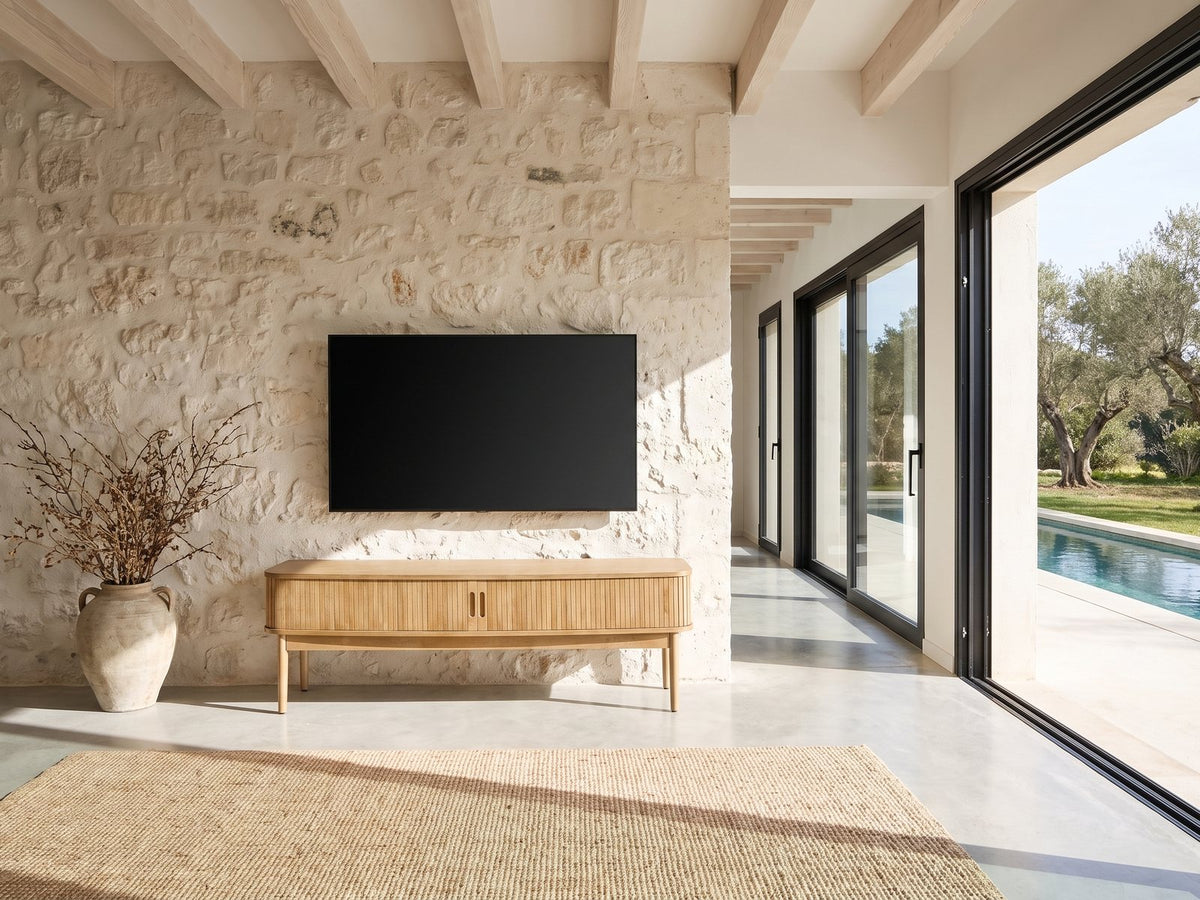 Atrani Reeded Curved Media Console under a wall-mounted screen on a pale stone wall in a poolside villa