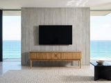 Atrani Reeded Curved Media Console under a wall-mounted screen in an oceanfront glass house