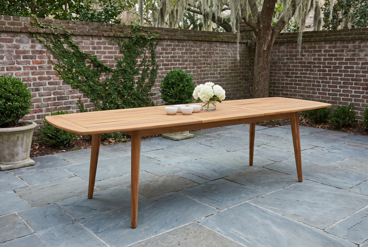 Augusta acacia dining table extended in a walled brick courtyard on bluestone flagstones, boxwood and a live oak with Spanish moss behind (chairs not included, bowls and flowers not included)