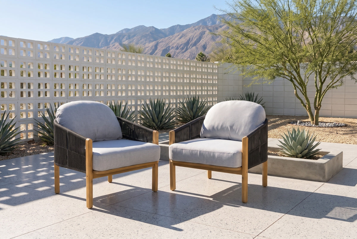 Two Avola club chairs on a terrazzo patio in Palm Springs, a white breeze-block wall, agaves and the San Jacinto mountains behind