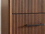Close-up of the Badia 56-Inch Walnut-Finish 6-Drawer Dresser: the reeded walnut-finish drawer fronts beside the rounded end of the case