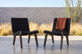 Two Bagheria lounge chairs on polished concrete at a house in Marfa, West Texas, a grey concrete block wall, golden grasses and an ocotillo behind (throw not included)