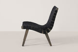 One Bagheria chair in straight side view: the curved acacia side rail, the strap ends wrapped round it and two splayed legs