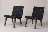 The pair of Bagheria outdoor lounge chairs in grey-brown acacia with black woven rope straps, three-quarter view on a light studio backdrop