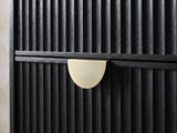 Close-up of the Bardolino 36-Inch Black Fluted 5-Drawer Chest: the brass-finish half-moon pull on the black fluted drawers