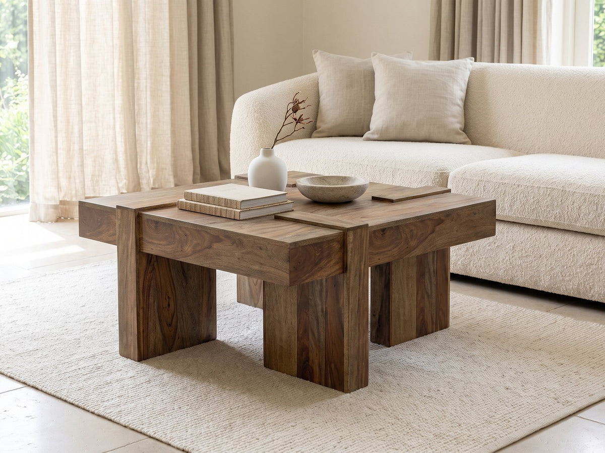 Barga Solid Sheesham Coffee Table styled with books, a vase and a stone bowl in front of a cream sofa in a bright plaster room