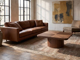 Bari Walnut Veneer Square Pedestal Coffee Table on a vintage rug in front of a leather sofa in an industrial loft
