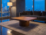 Bari Walnut Veneer Square Pedestal Coffee Table on a wool rug in front of a velvet sofa in a city penthouse at blue hour