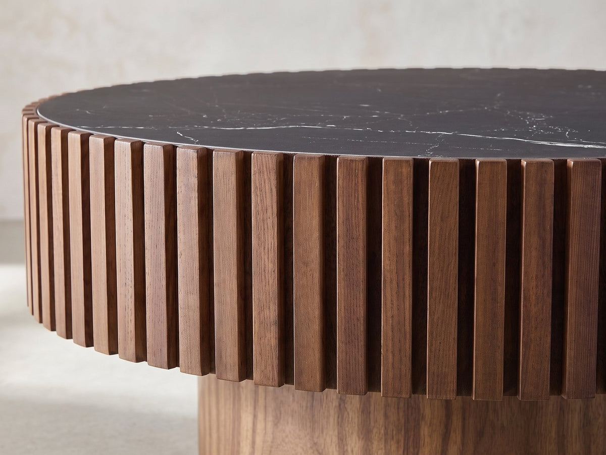 Close-up of the Barolo 35-Inch Round Black Sintered Stone Slatted Drum Coffee Table: the ring of walnut slats around the black stone top