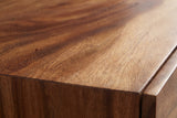Close-up of the suar on the Barumini nightstand: bold flowing grain in reddish brown and honey running to a square edge