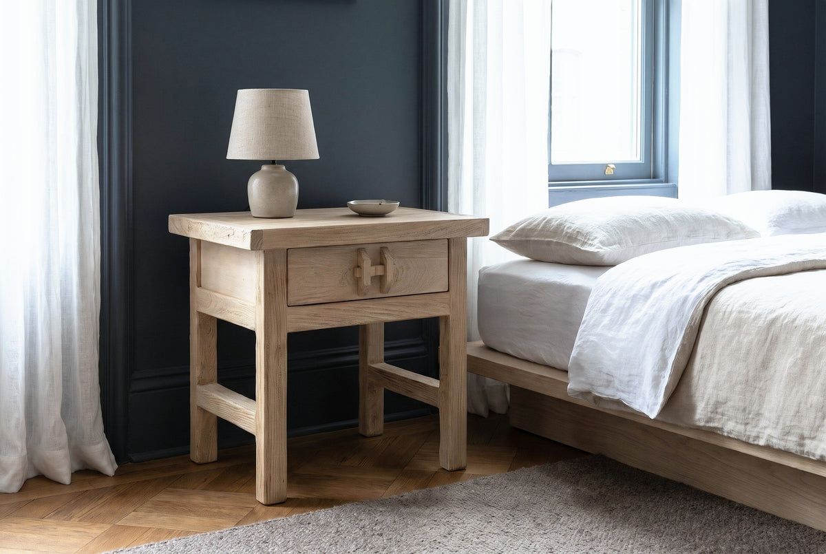 Baunei reclaimed elm nightstand against a dark blue-grey wall in a Brooklyn brownstone bedroom with a herringbone floor