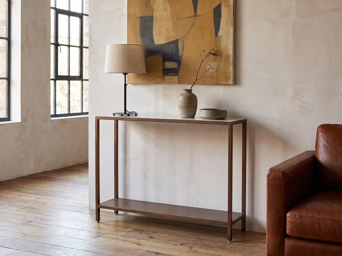 Bellegra White Marble Console Table against a plaster wall in an industrial loft