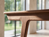 Close-up of the Belluno Solid Walnut Media Cabinet: the sculpted walnut leg joint and apron under the cabinet