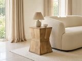 Belmonte Mango Wood Hourglass Side Table with a lamp and a ceramic bowl beside a cream boucle sofa in a bright plaster room