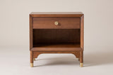 The Berchidda nightstand in walnut veneer, front view on a light studio backdrop